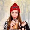 Millennial teenage girl drinking takeaway coffee, wearing modern black and white outfit.